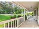 Covered front porch with white rails overlooking a lawn and landscaping at 1757 Mystery Sw Cir, Conyers, GA 30094