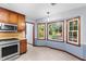 Bright kitchen featuring an oven, a microwave, wood cabinets, and tile floors with bay windows at 1757 Mystery Sw Cir, Conyers, GA 30094