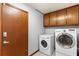 A well-equipped laundry room with modern washer and dryer units and storage cabinets at 1757 Mystery Sw Cir, Conyers, GA 30094