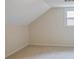 Unfinished attic space with a dormer window and carpeted floors at 3323 Lancing Ct, Duluth, GA 30096