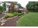 Backyard featuring a stone path, garden, green grass, and lush landscaping at 3323 Lancing Ct, Duluth, GA 30096
