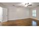 Bedroom with hardwood floors, ceiling fan, and natural light from shuttered window at 3323 Lancing Ct, Duluth, GA 30096