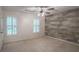 Bedroom with a gray wood accent wall, two windows, and a ceiling fan at 3323 Lancing Ct, Duluth, GA 30096