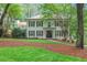 Charming white brick two-story home featuring black shutters, a well-manicured lawn, and mature trees at 3323 Lancing Ct, Duluth, GA 30096