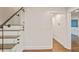 Hallway with wood flooring, light walls, glass-paneled staircase, and white trim at 3323 Lancing Ct, Duluth, GA 30096