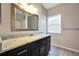 Bathroom with dark cabinets, granite counters, large mirror and tub shower combo at 5600 Walnut Creek Nw Ct, Lilburn, GA 30047