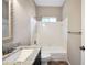 Bathroom with granite countertop and bath-shower combination with white tile surround at 5600 Walnut Creek Nw Ct, Lilburn, GA 30047
