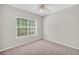An empty bedroom featuring carpet floors and a large window for natural light at 5600 Walnut Creek Nw Ct, Lilburn, GA 30047