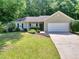 Lovely single-story home featuring green lawn, complemented by mature trees at 5600 Walnut Creek Nw Ct, Lilburn, GA 30047