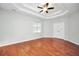 Large main bedroom with hardwood floors, tray ceiling, and a ceiling fan at 5600 Walnut Creek Nw Ct, Lilburn, GA 30047