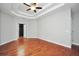 Main bedroom with hardwood floors, tray ceilings, ceiling fan, and neutral paint at 5600 Walnut Creek Nw Ct, Lilburn, GA 30047