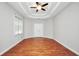 Bright main bedroom features hardwood floors, tray ceiling, and neutral paint at 5600 Walnut Creek Nw Ct, Lilburn, GA 30047