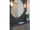 The bathroom vanity has a gray cabinet and counter top, with brass fixtures and a round mirror at 225 River Valley Ct, Atlanta, GA 30328