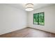 Bright bedroom with hardwood floors, large window showcasing lush green views, and contemporary light fixture at 225 River Valley Ct, Atlanta, GA 30328