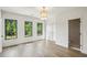 Spacious bedroom with hardwood flooring, natural light from three windows, and ensuite bathroom access at 225 River Valley Ct, Atlanta, GA 30328