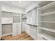 Walk-in closet with custom shelving, drawers and hanging rods and hardwood floors at 225 River Valley Ct, Atlanta, GA 30328
