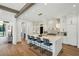 Open kitchen features white cabinets, large island, and stainless steel appliances with wood floors at 225 River Valley Ct, Atlanta, GA 30328