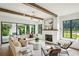 Bright living room with wood beams, fireplace, and glass doors leading to the outdoors at 225 River Valley Ct, Atlanta, GA 30328