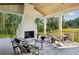 Inviting outdoor covered patio with fireplace, stylish seating, and views of the landscaped backyard at 225 River Valley Ct, Atlanta, GA 30328
