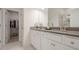 Bright bathroom featuring double sinks with gray countertops and a walk in closet at 3693 Allegretto Cir, Atlanta, GA 30339