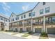 Exterior view of townhomes featuring garages, patios, and landscaped yards at 3693 Allegretto Cir, Atlanta, GA 30339