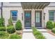 Close up on the exteriors of townhomes with gray painted brick, lovely doors, and manicured landscaping at 3693 Allegretto Cir, Atlanta, GA 30339