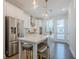 Modern kitchen with stainless steel appliances, white cabinetry, island with bar stools, and wood floors at 3693 Allegretto Cir, Atlanta, GA 30339