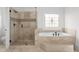 Bathroom showcasing glass shower door, tile surround, and a soaking tub beneath a decorative stained-glass window at 8805 Marion Dr, Duluth, GA 30097