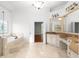 Elegant bathroom featuring a soaking tub, marble tile, double vanities, and plenty of natural light at 8805 Marion Dr, Duluth, GA 30097