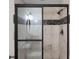 Bathroom featuring a sliding glass shower door and neutral stone tile at 8805 Marion Dr, Duluth, GA 30097