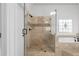 Bathroom featuring glass shower door, tile surround, and a soaking tub beneath a decorative stained-glass window at 8805 Marion Dr, Duluth, GA 30097