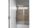 Neutral bathroom with tile shower, glass door, and small window at 8805 Marion Dr, Duluth, GA 30097