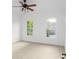 Bright bedroom with neutral carpet, two windows, and a ceiling fan at 8805 Marion Dr, Duluth, GA 30097