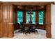 Wood paneled dining room with a round table and several windows overlooking the greenery at 8805 Marion Dr, Duluth, GA 30097