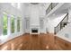 Bright open-concept living room featuring fireplace, staircase, and large windows at 8805 Marion Dr, Duluth, GA 30097