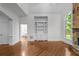 Living room featuring hardwood floors, a stone fireplace, and built-in shelving at 8805 Marion Dr, Duluth, GA 30097