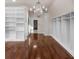 Expansive walk-in closet featuring custom shelving, hardwood floors, and a sparkling chandelier at 8805 Marion Dr, Duluth, GA 30097