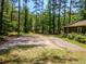 Gravel parking pad with mature trees offering a versatile space on this wooded lot at 5216 Wheeler Dr, Loganville, GA 30052