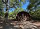 View of the barn with large doors, nestled among mature trees, adding extra outdoor storage at 5216 Wheeler Dr, Loganville, GA 30052