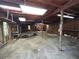 Rustic barn interior featuring exposed beams, multiple lights, and concrete floors; offers ample space at 5216 Wheeler Dr, Loganville, GA 30052