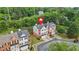 An aerial view showcases this brick townhome with red shutters and an attached garage in a lush, green neighborhood at 5989 Turfway Park Ct, Sugar Hill, GA 30518