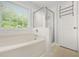 This bright bathroom features a shower, soaking tub, and a door at 5989 Turfway Park Ct, Sugar Hill, GA 30518