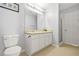 Bright bathroom featuring double sinks, white cabinets, and well-lit vanity area at 5989 Turfway Park Ct, Sugar Hill, GA 30518
