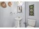 Pedestal sink, toilet and decorative art in renovated bathroom with modern decorative style at 5989 Turfway Park Ct, Sugar Hill, GA 30518