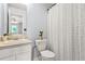 Cozy bathroom features a single sink vanity, toilet, and shower with a modern patterned curtain at 5989 Turfway Park Ct, Sugar Hill, GA 30518
