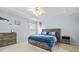 This bedroom features carpet, ceiling fan, a bed with blue bedding, and a window for natural light at 5989 Turfway Park Ct, Sugar Hill, GA 30518