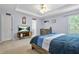 This bedroom features carpet, a ceiling fan, a bed with blue bedding, and a television at 5989 Turfway Park Ct, Sugar Hill, GA 30518