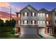 Attractive townhouse with a two-car garage, neutral siding, and brick accents against a colorful sunset at 5989 Turfway Park Ct, Sugar Hill, GA 30518
