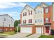 Attractive townhouse featuring a two-car garage, neutral siding, red shutters, and a well-maintained lawn at 5989 Turfway Park Ct, Sugar Hill, GA 30518