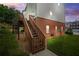 View of the side of the building with stairs leading to a deck, and partial brick facade at 5989 Turfway Park Ct, Sugar Hill, GA 30518